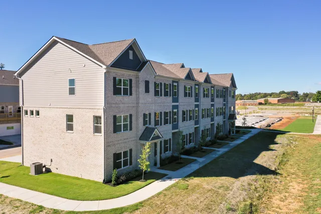 a front view of a house with a yard and lake view