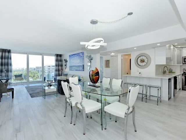 a room with a table chairs and a refrigerator