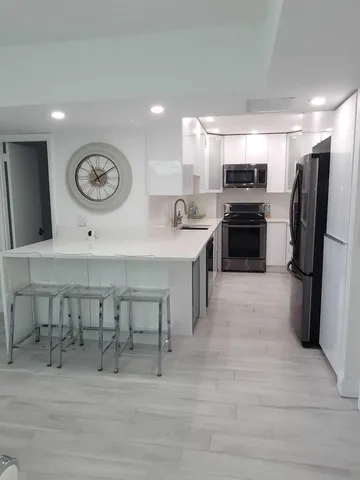 a kitchen with stainless steel appliances a refrigerator a stove a microwave and cabinets