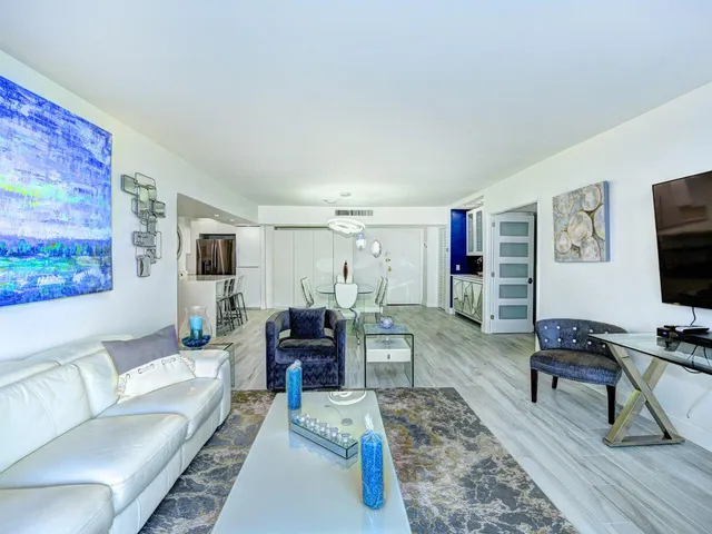 a living room with furniture and a painting on the wall