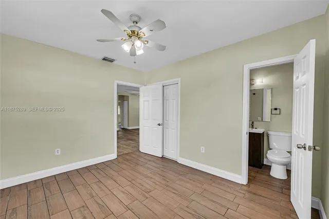 wooden floor in an empty room with a bathroom