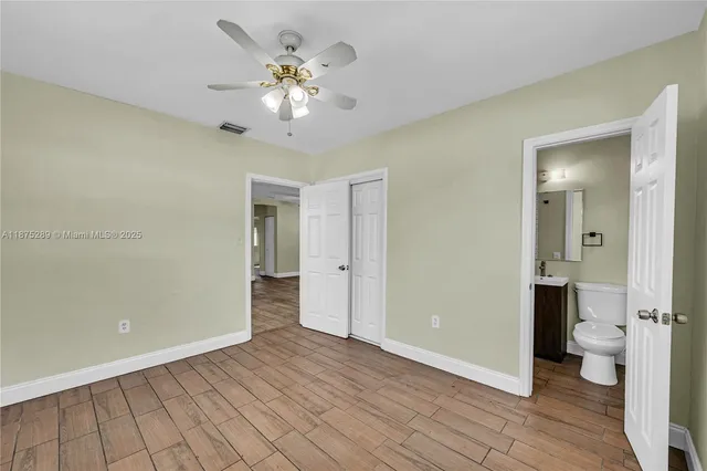 wooden floor in an empty room with a bathroom