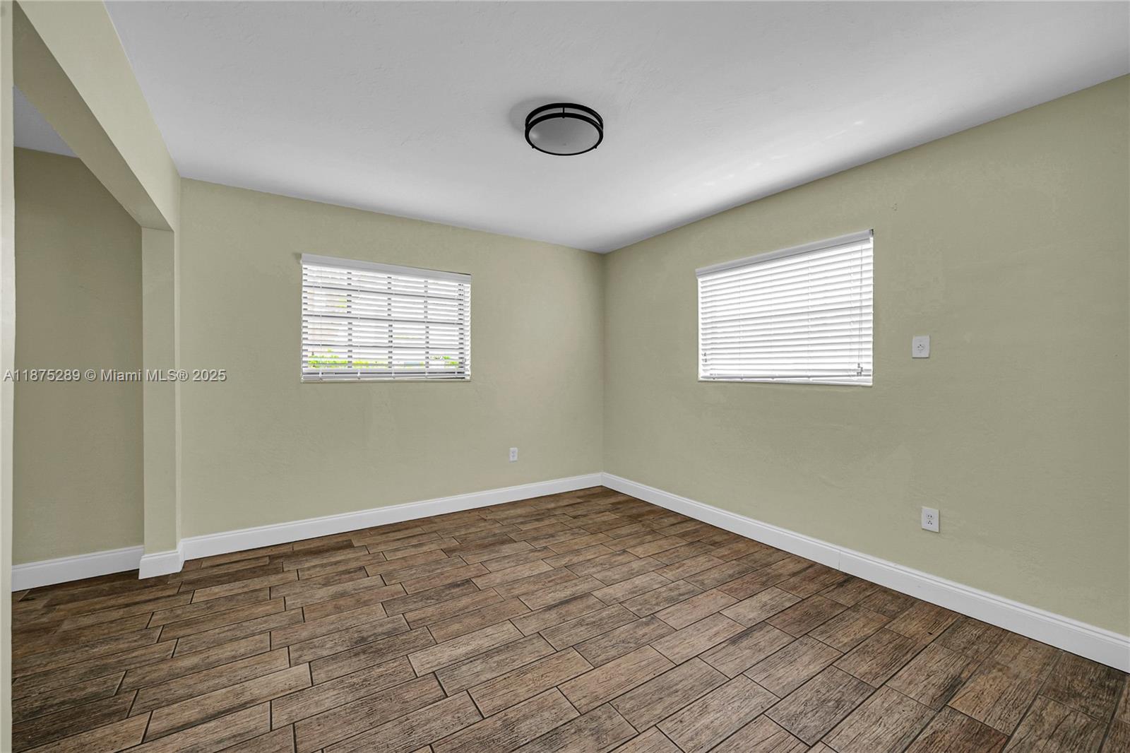 17130 Northeast 7th Avenue North Miami Beach, FL 33162 - Photo 20 of 38 an empty room with wooden floor and windows