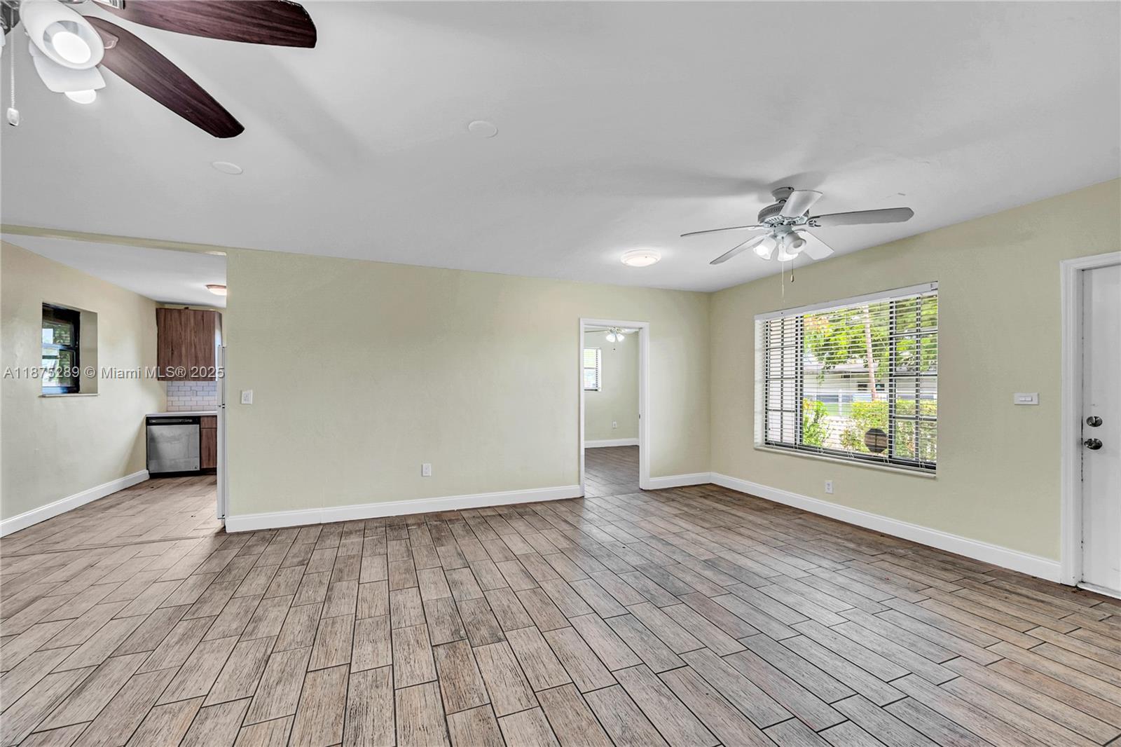 17130 Northeast 7th Avenue North Miami Beach, FL 33162 - Photo 4 of 38 a view of an empty room with a window and wooden floor