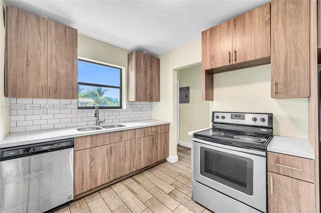 a kitchen with granite countertop wooden cabinets stainless steel appliances and a window