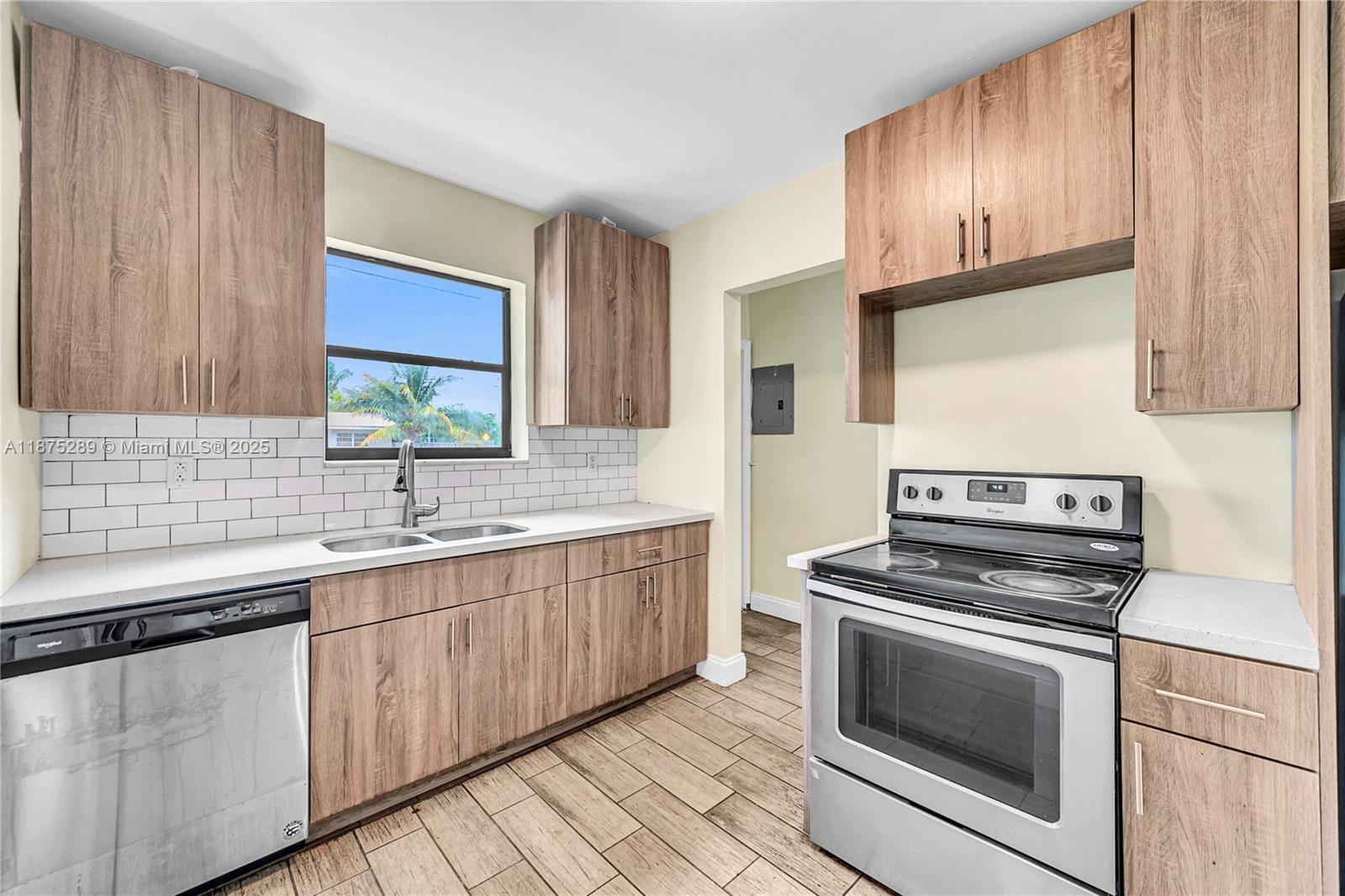 17130 Northeast 7th Avenue North Miami Beach, FL 33162 - Photo 7 of 38 a kitchen with granite countertop wooden cabinets stainless steel appliances and a window