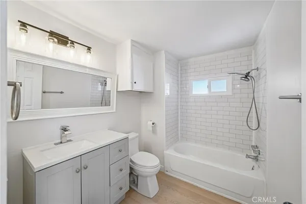 a bathroom with a bathtub shower sink vanity and toilet