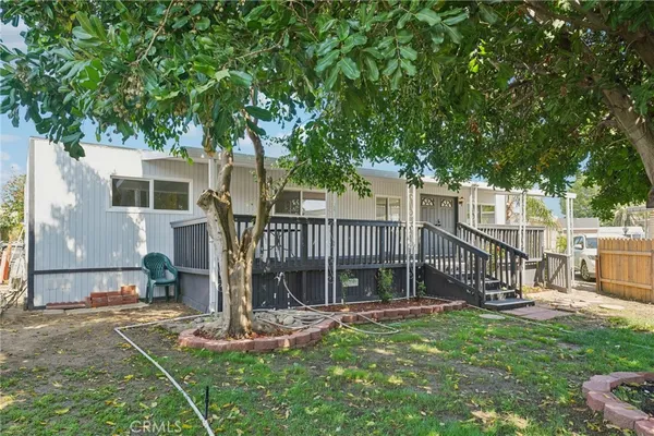 a view of a house with backyard and a tree