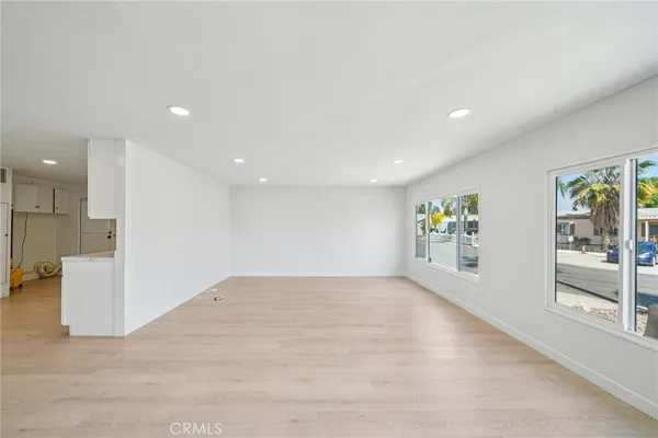 an empty room with kitchen and windows