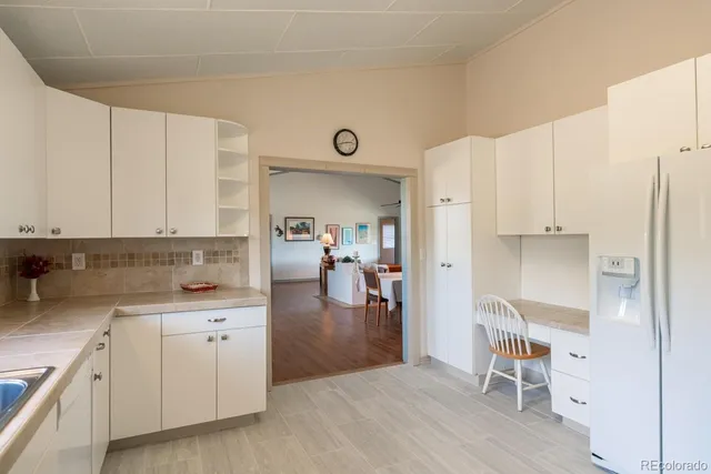 a kitchen with a sink window and cabinets