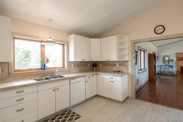 a kitchen with a large window sink and cabinets