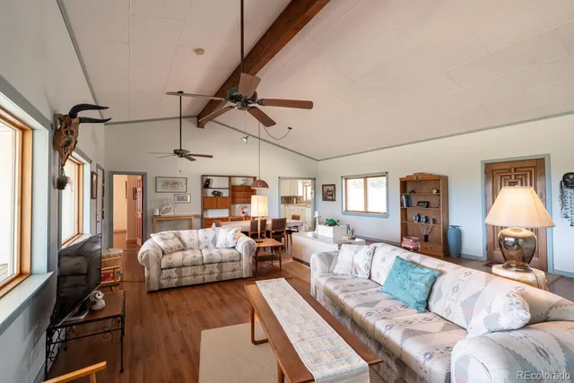a living room with furniture a chandelier and a flat screen tv