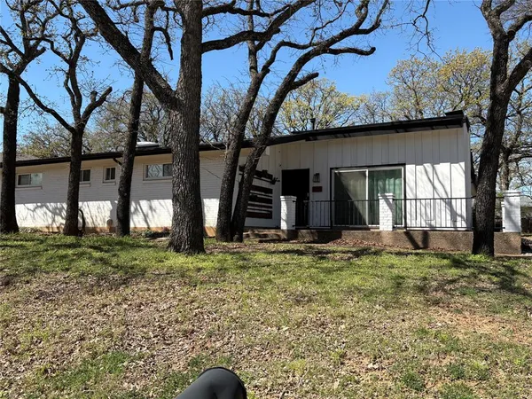 a view of a house with a large tree and a yard