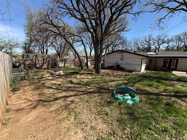 a view of yard with tree in front of it