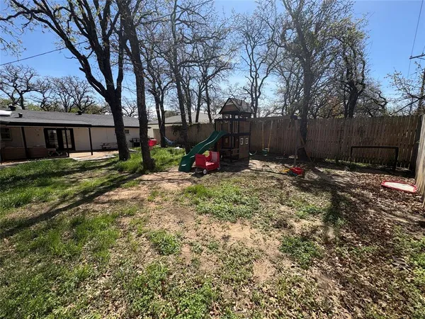 a view of garden with wooden fence