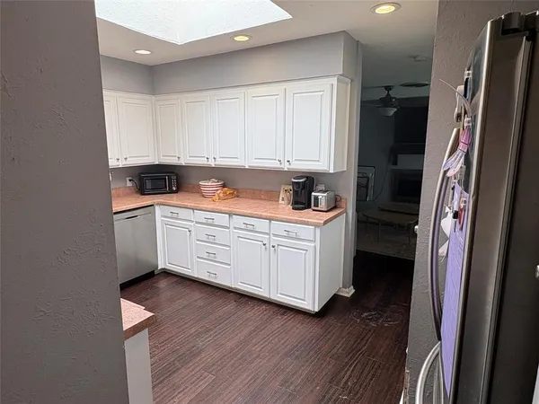 a kitchen with a sink a refrigerator and cabinets