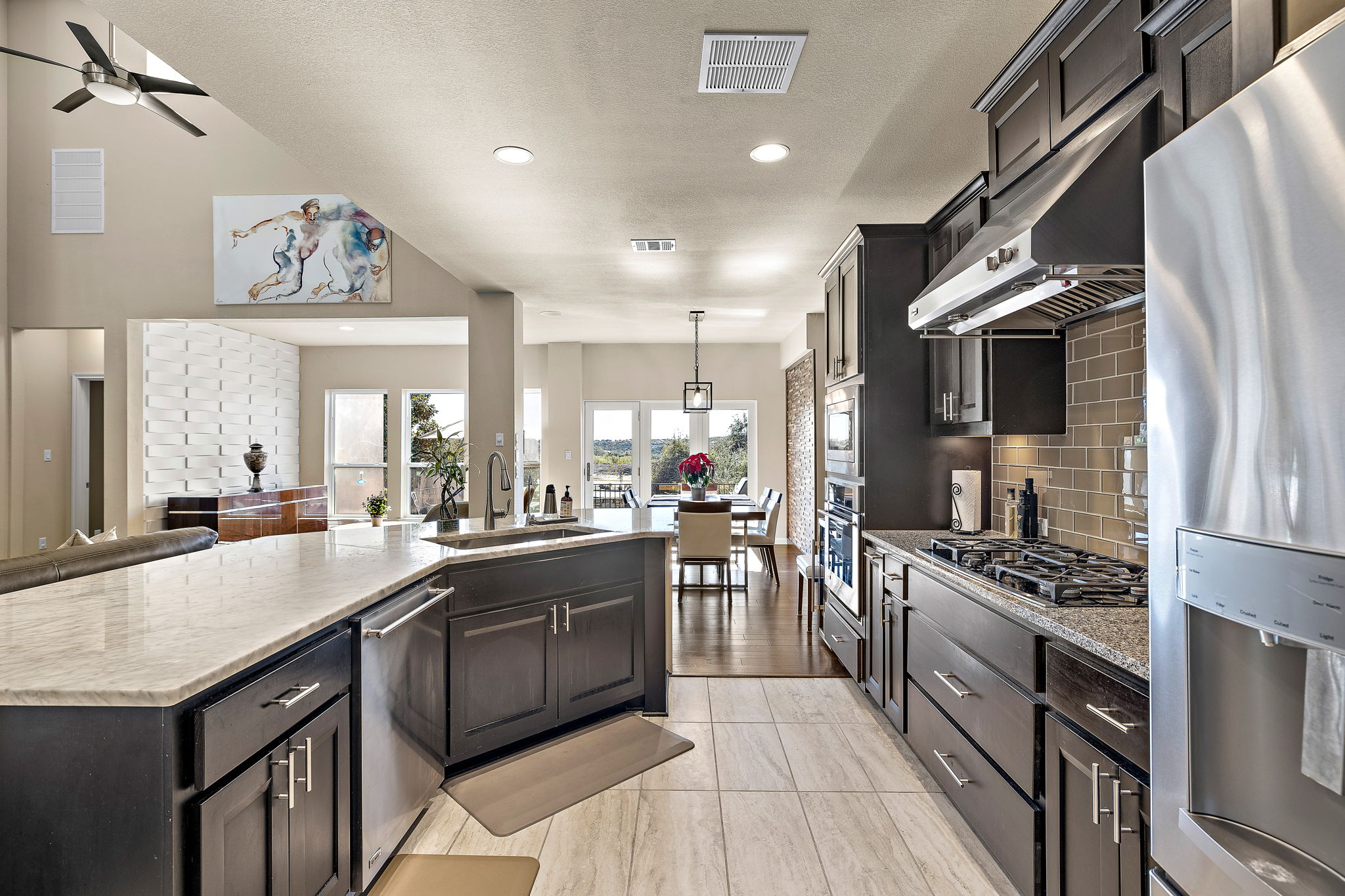 4413 Tambre Bend Austin, TX 78738 - Photo 7 of 30 a kitchen with stainless steel appliances granite countertop a sink a stove and a refrigerator
