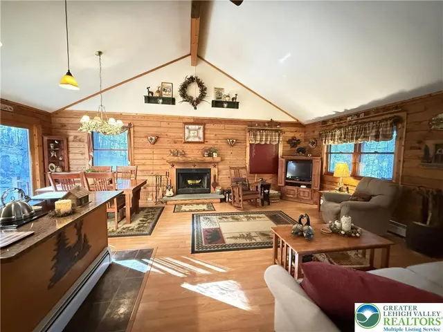 a living room with furniture a fireplace and a ceiling fan