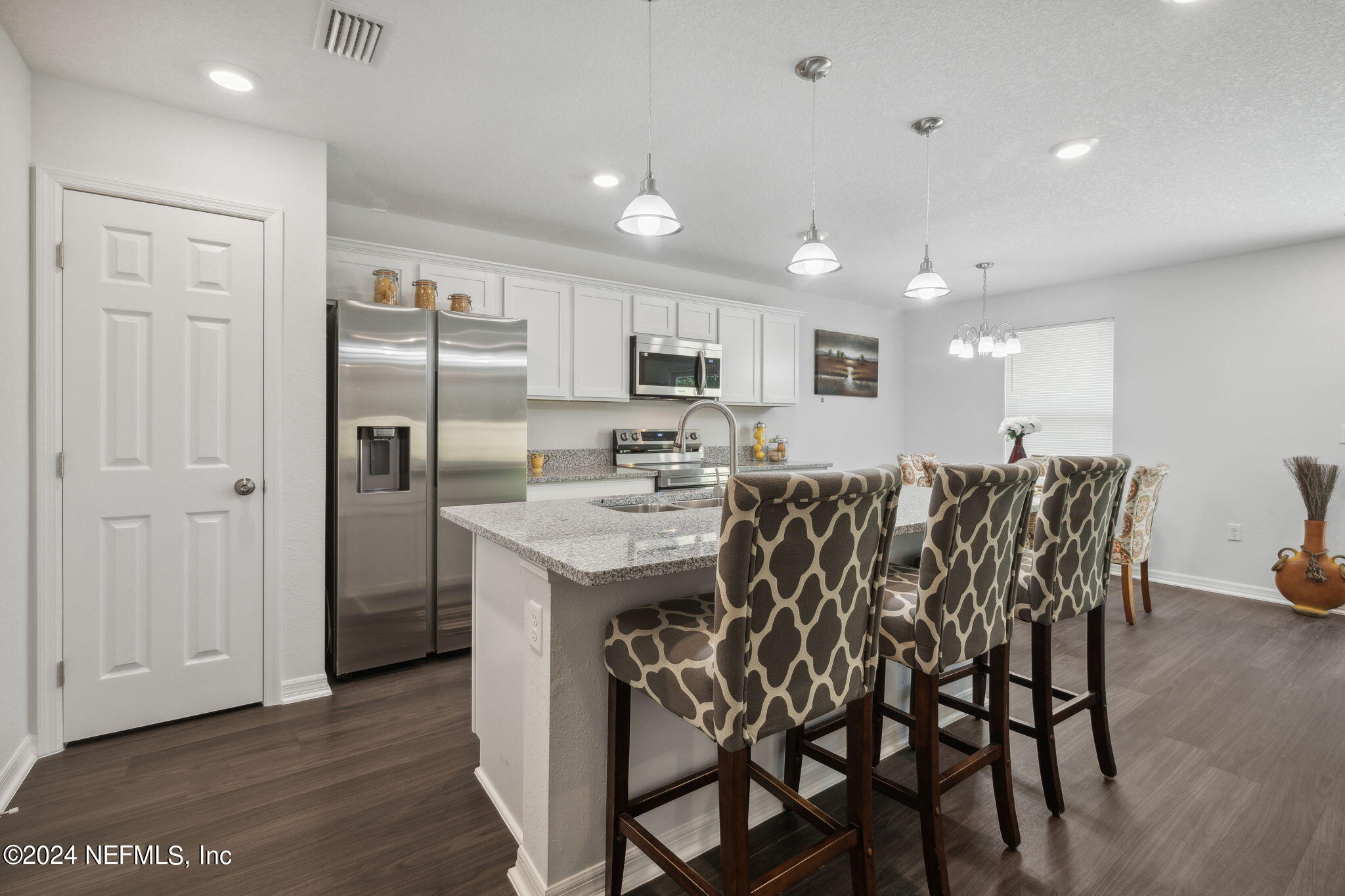 8320 Maple Street Jacksonville, FL 32244 - Photo 11 of 32 a kitchen with stainless steel appliances kitchen island granite countertop a refrigerator and microwave