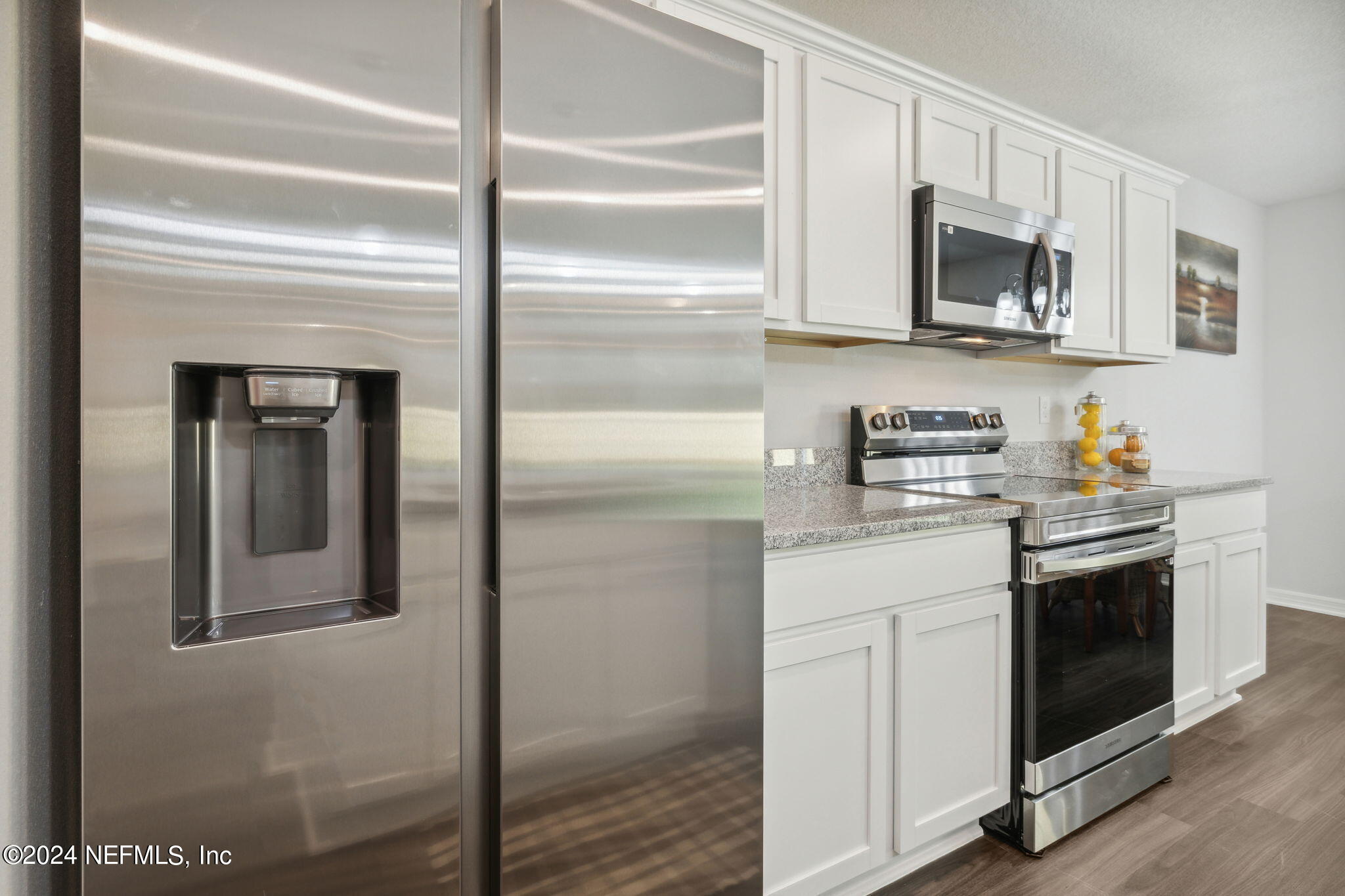 8320 Maple Street Jacksonville, FL 32244 - Photo 12 of 32 a kitchen with stainless steel appliances granite countertop white cabinets and window