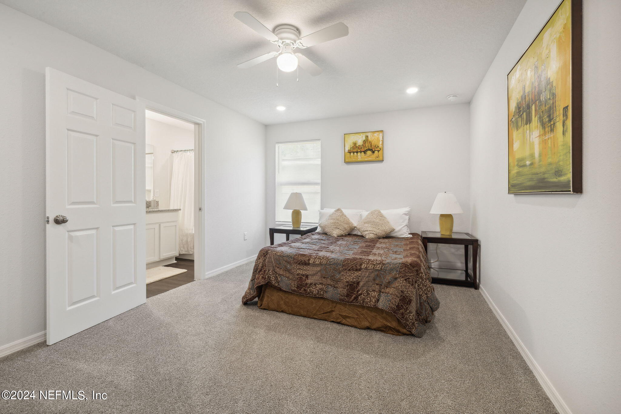 8320 Maple Street Jacksonville, FL 32244 - Photo 16 of 32 a spacious bedroom with a bed and a painting on the wall