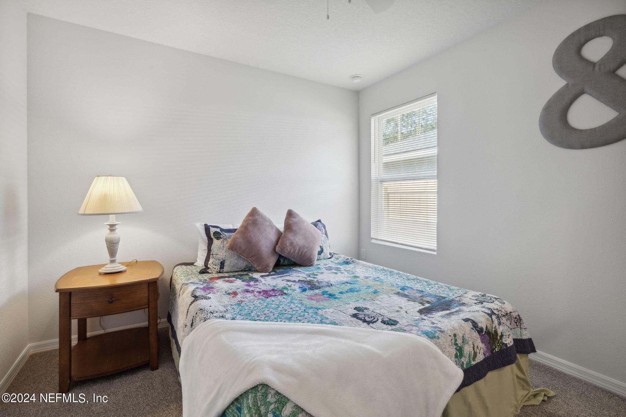 8320 Maple Street Jacksonville, FL 32244 - Photo 22 of 32 a large bed sitting in a bedroom next to a lamp