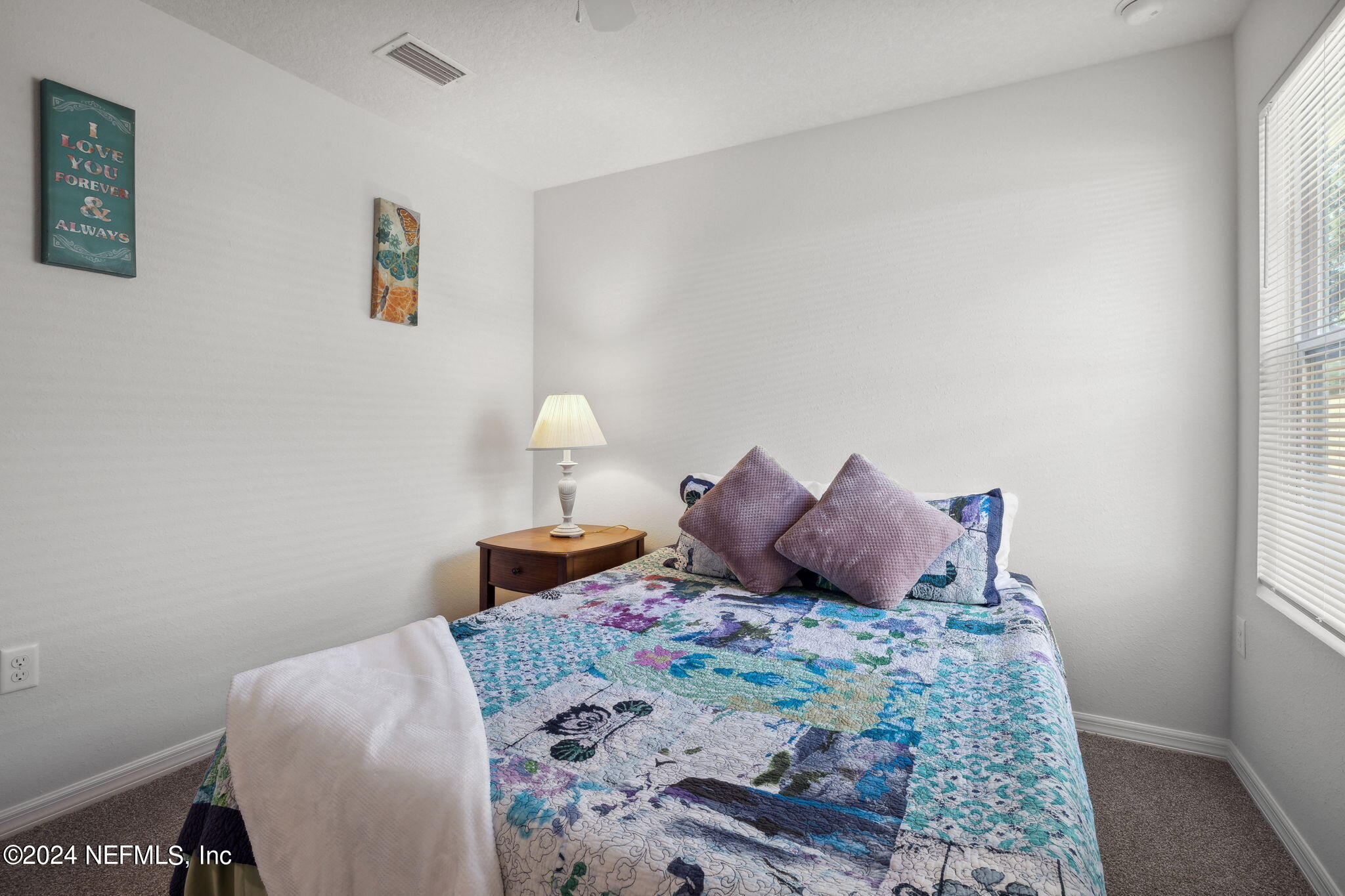 8320 Maple Street Jacksonville, FL 32244 - Photo 23 of 32 a bed sitting in a bedroom next to a window