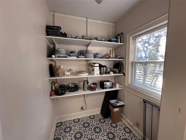 a room with stainless steel appliances a rug and a window