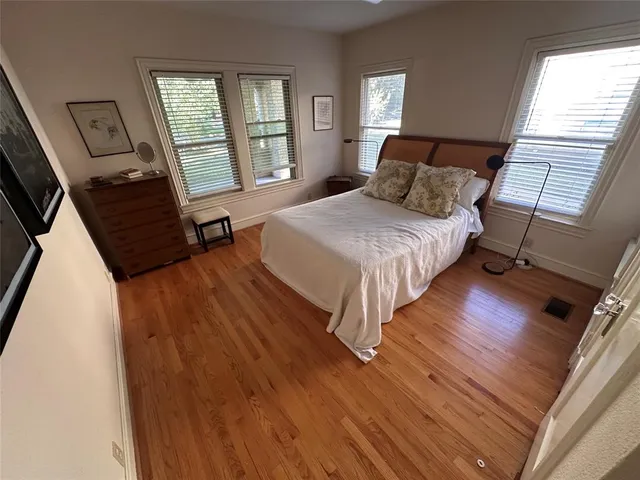 a bedroom with a bed mirror and a window