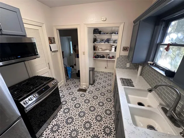 a kitchen with granite countertop a stove a sink and a microwave