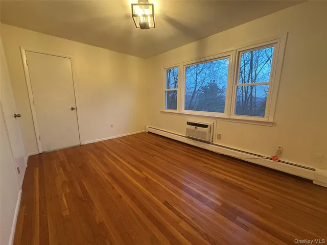 a view of a room with wooden floor and window