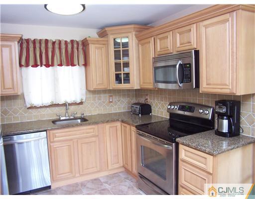2 Crabtree Road Old Bridge, NJ 07747 - Photo 9 of 13 a kitchen with granite countertop a sink a stove and cabinets
