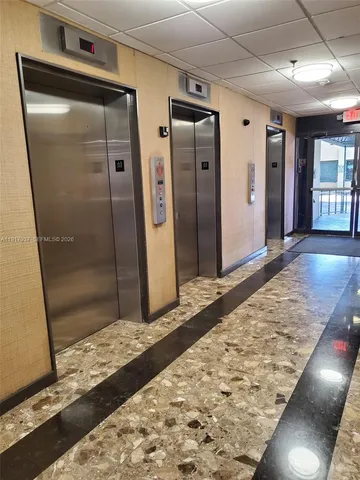 a view of a hallway with wooden door and wooden floor