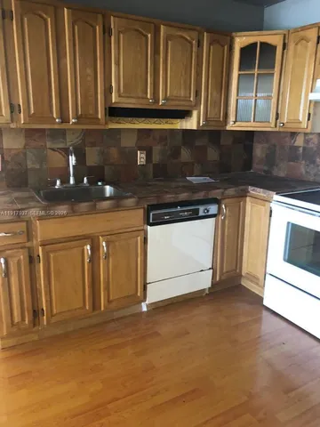 a kitchen with granite countertop a stove and a sink