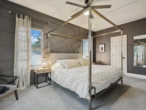 a bedroom with a bed and large window