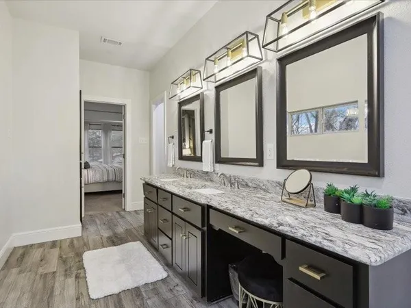 a bathroom with a granite countertop double vanity sink and a mirror
