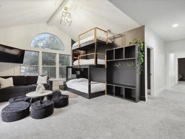 a spacious bedroom with a bed and a chandelier