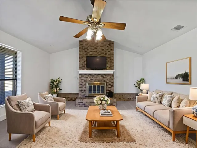 a living room with furniture a fireplace and a chandelier