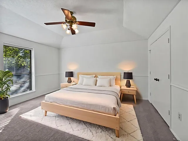 a bedroom with a bed and a large window