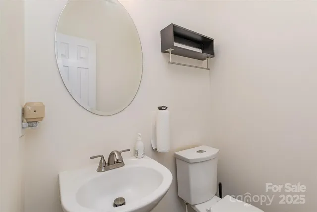a bathroom with a sink a toilet and a mirror