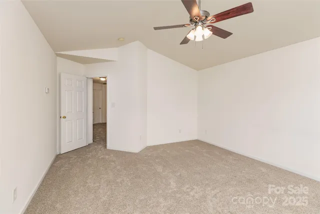 an empty room with fan and entryway