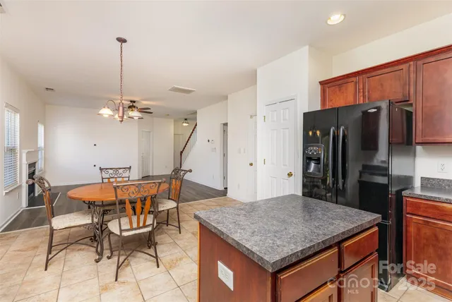 a kitchen with stainless steel appliances granite countertop a kitchen island a table and chairs