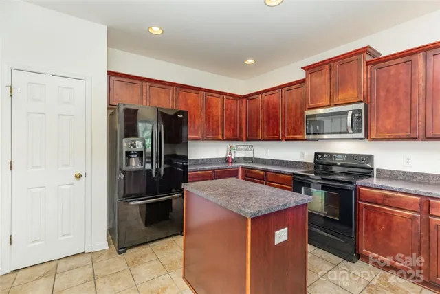 a kitchen with stainless steel appliances granite countertop a refrigerator stove top oven and sink
