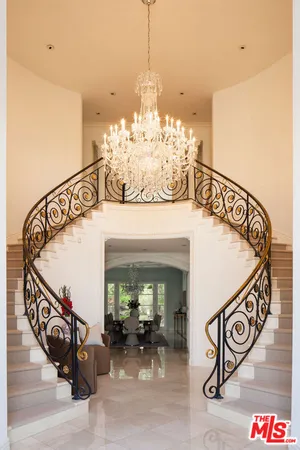 a view of a hallway with dining room and chandelier