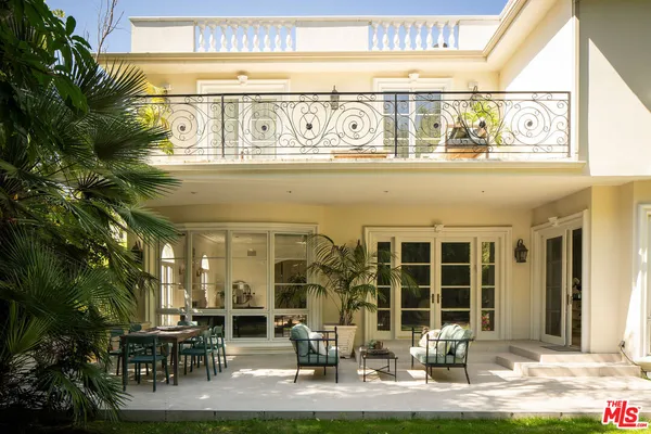 a front view of a building with outdoor seating and plants