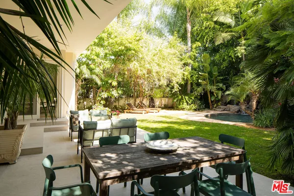 a view of a patio with table and chairs and potted plants