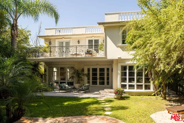 a view of a house with a swimming pool and sitting area