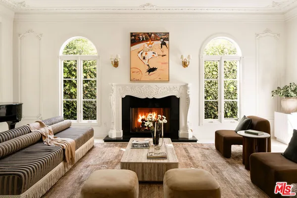 a living room with furniture a fireplace and a large window
