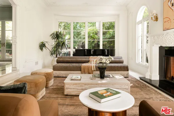 a living room with furniture fireplace and a large window