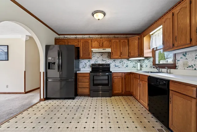 a kitchen with granite countertop a refrigerator and a sink